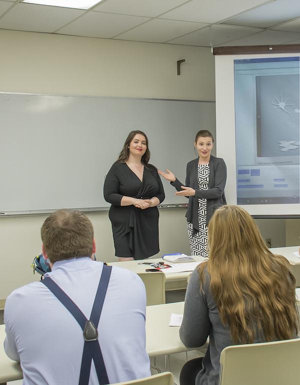 Two students presenting a project in front of their classmates