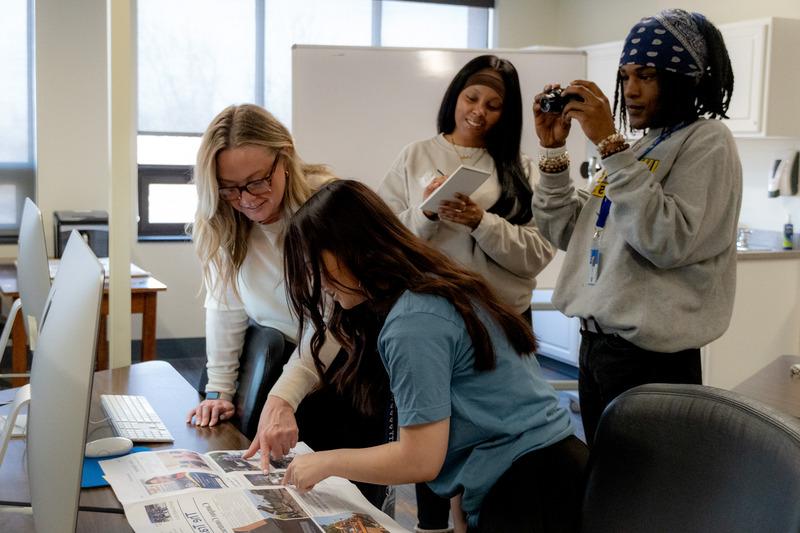 A communications major speaking to two other students